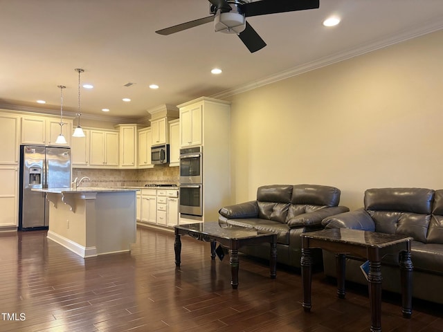 kitchen with an island with sink, stainless steel appliances, tasteful backsplash, a kitchen breakfast bar, and pendant lighting