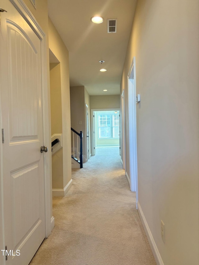 hallway with light colored carpet