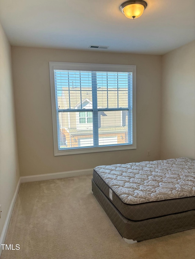 bedroom featuring multiple windows and carpet