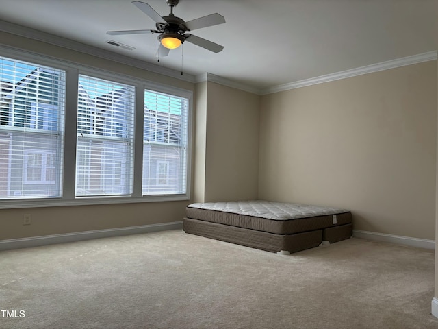 unfurnished bedroom featuring ceiling fan, crown molding, and carpet floors