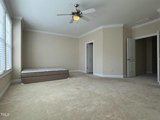 unfurnished bedroom with ceiling fan, light colored carpet, and crown molding