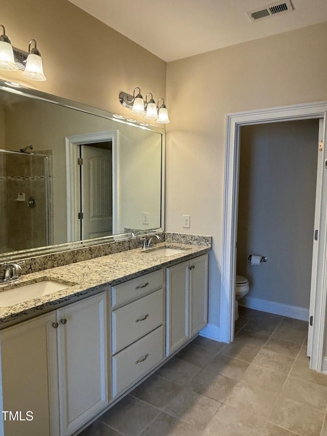 bathroom with toilet, tile patterned flooring, a shower with door, and vanity