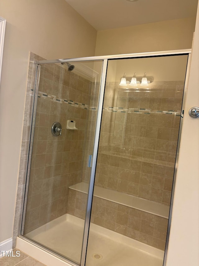 bathroom featuring a shower with shower door and tile patterned flooring