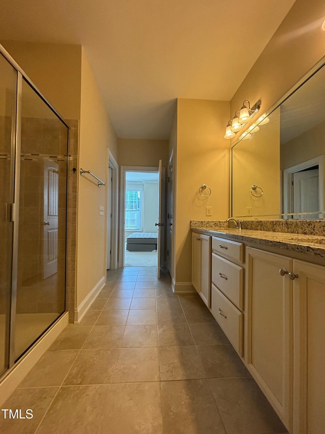 bathroom featuring a shower with shower door, vanity, and tile patterned flooring