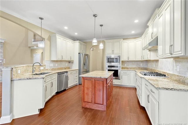 kitchen with sink, stainless steel appliances, a center island, decorative light fixtures, and kitchen peninsula