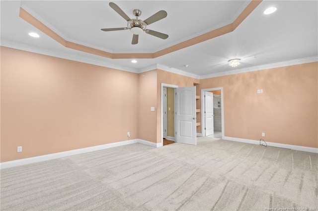 spare room featuring crown molding, light carpet, ceiling fan, and a tray ceiling