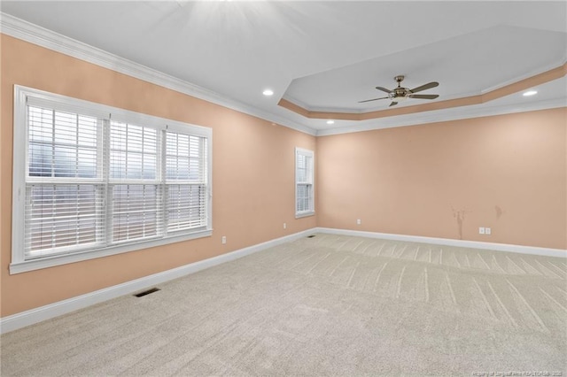 carpeted empty room featuring crown molding, ceiling fan, and a tray ceiling