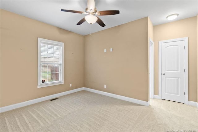 spare room with ceiling fan and light colored carpet