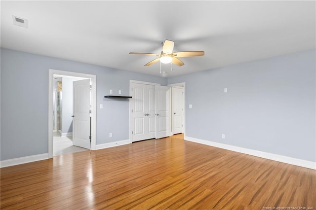 unfurnished bedroom featuring ensuite bath, light hardwood / wood-style flooring, and ceiling fan