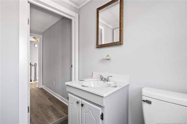 bathroom with toilet, wood-type flooring, and vanity