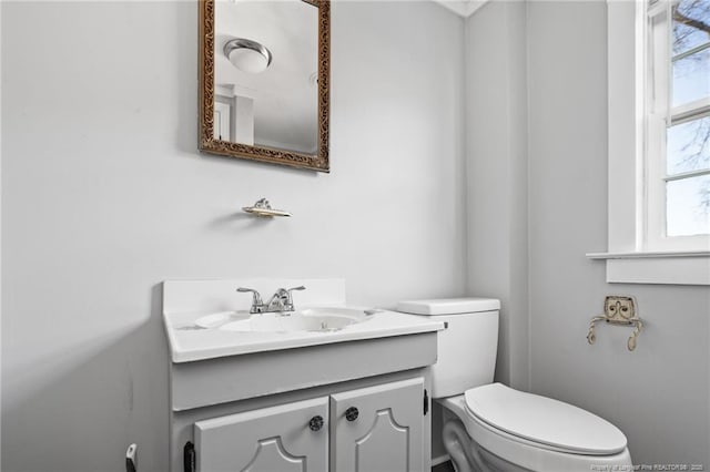 bathroom featuring plenty of natural light, toilet, and vanity