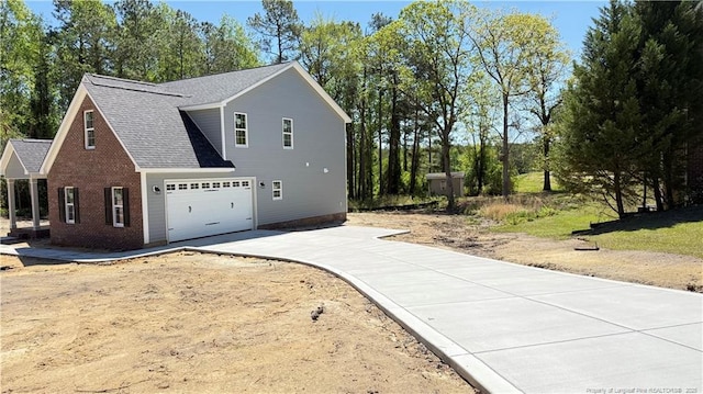 425 Shawcroft Rd, Fayetteville, NC 28311 - view of side of property featuring concrete driveway, brick siding, a garage, and a shingled roof
