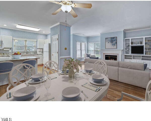 dining room featuring crown molding, ceiling fan, and light hardwood / wood-style flooring