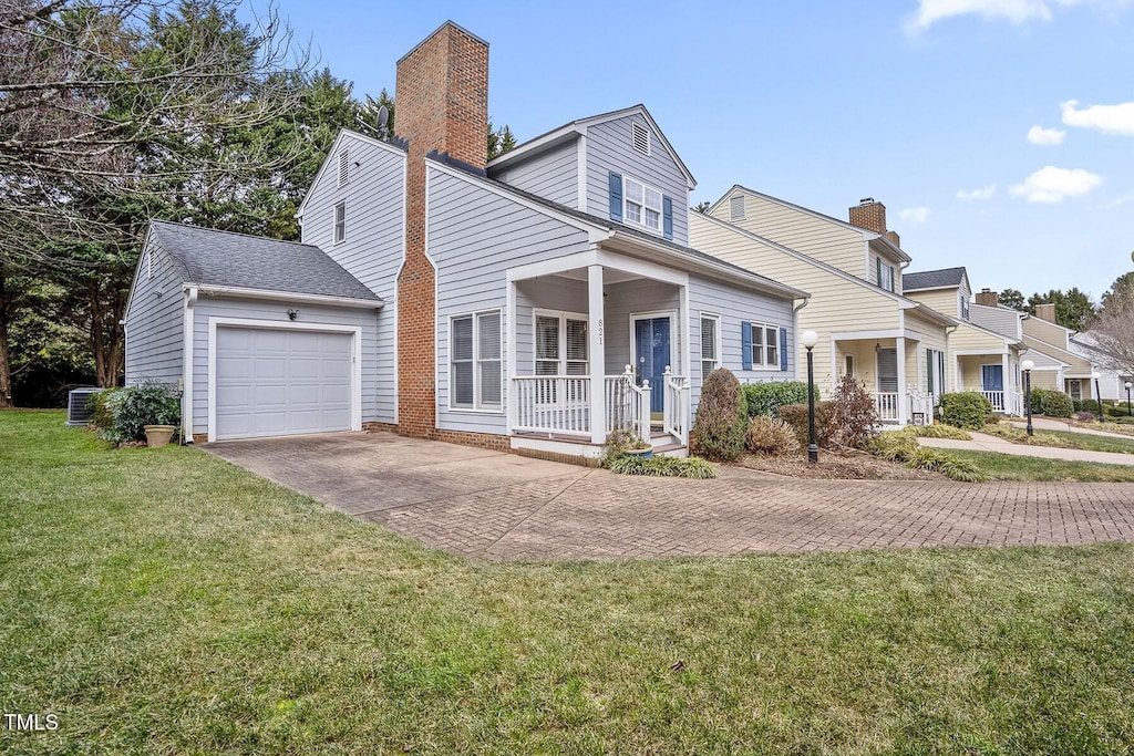 view of front facade featuring cooling unit, a garage, a front lawn, and a porch