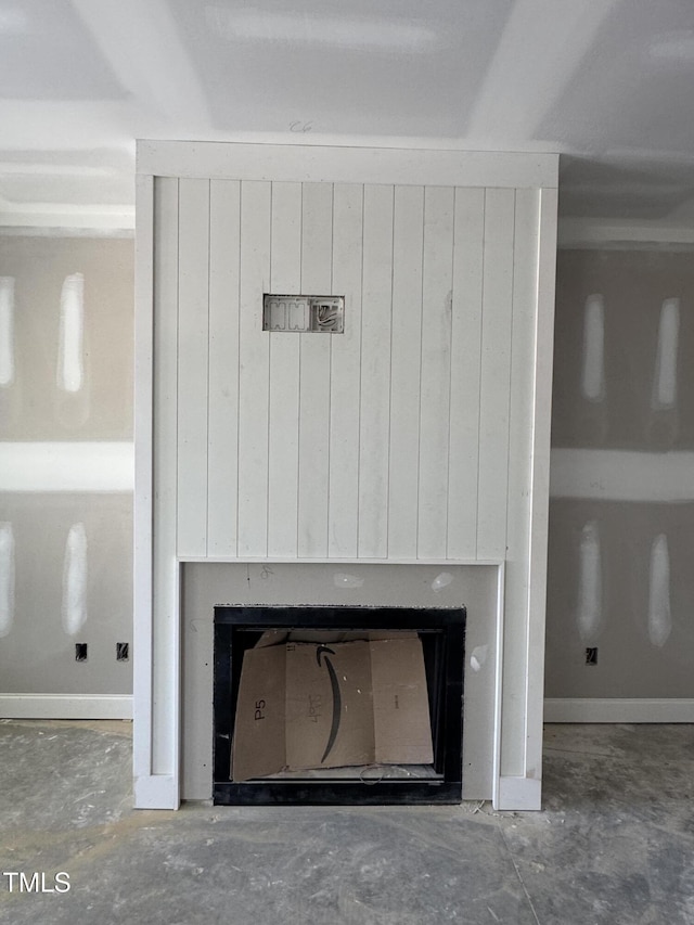 room details featuring concrete floors, a fireplace, and baseboards