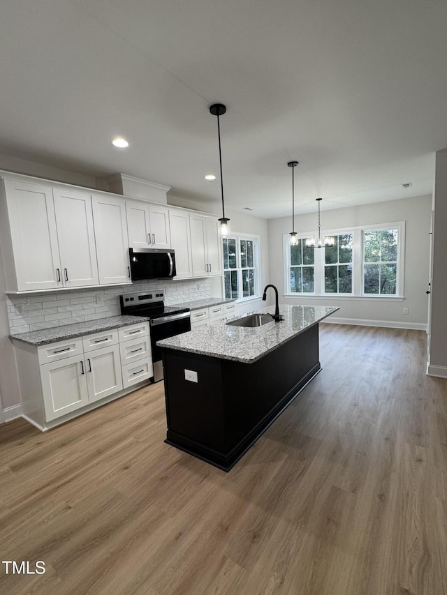 504 Tucker St, Four Oaks, NC 27524 - kitchen featuring a sink, white cabinetry, appliances with stainless steel finishes, light wood-style floors, and decorative backsplash