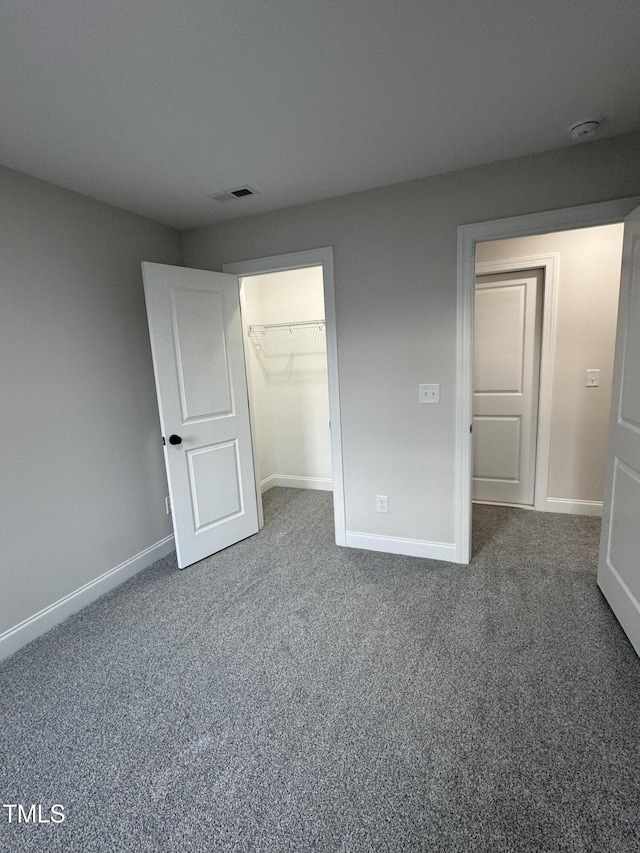 504 Tucker St, Four Oaks, NC 27524 - unfurnished bedroom featuring baseboards, visible vents, a closet, and dark carpet