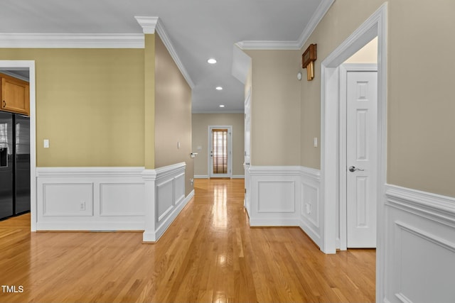 hallway with ornamental molding and light wood-type flooring