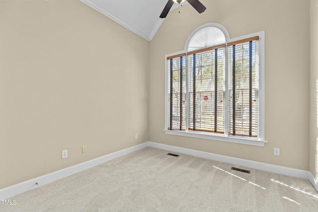 carpeted empty room featuring lofted ceiling, plenty of natural light, ornamental molding, and ceiling fan