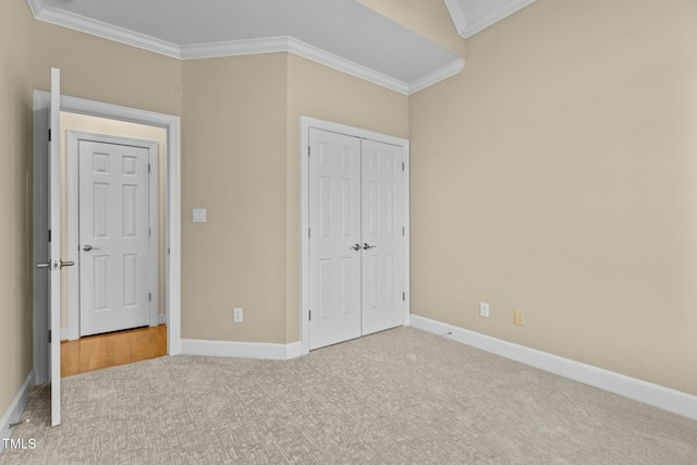 unfurnished bedroom with crown molding, a closet, and carpet