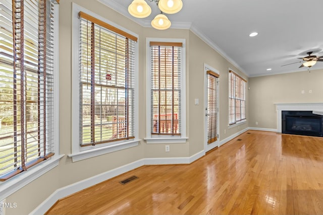 unfurnished living room featuring crown molding, ceiling fan, and hardwood / wood-style floors