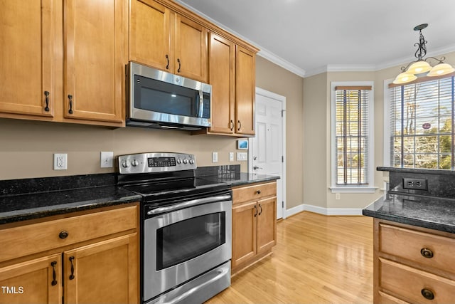 kitchen with dark stone counters, hanging light fixtures, stainless steel appliances, crown molding, and light wood-type flooring