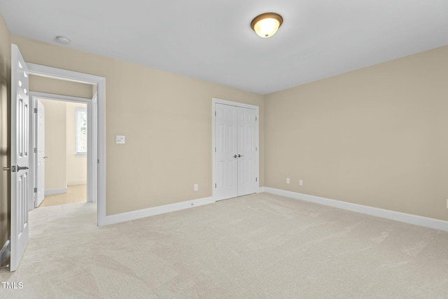 unfurnished bedroom featuring a closet and light carpet