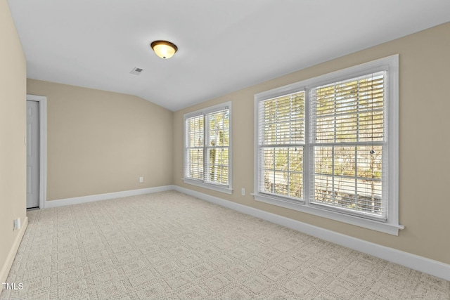 spare room with lofted ceiling and light carpet