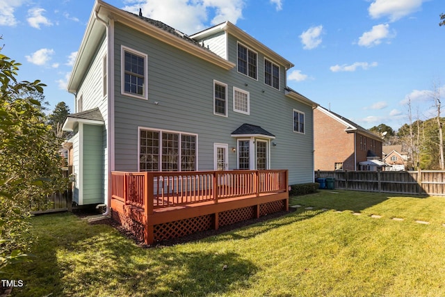 back of house featuring a wooden deck and a lawn