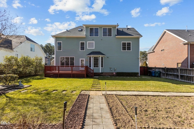 back of house featuring a wooden deck and a lawn