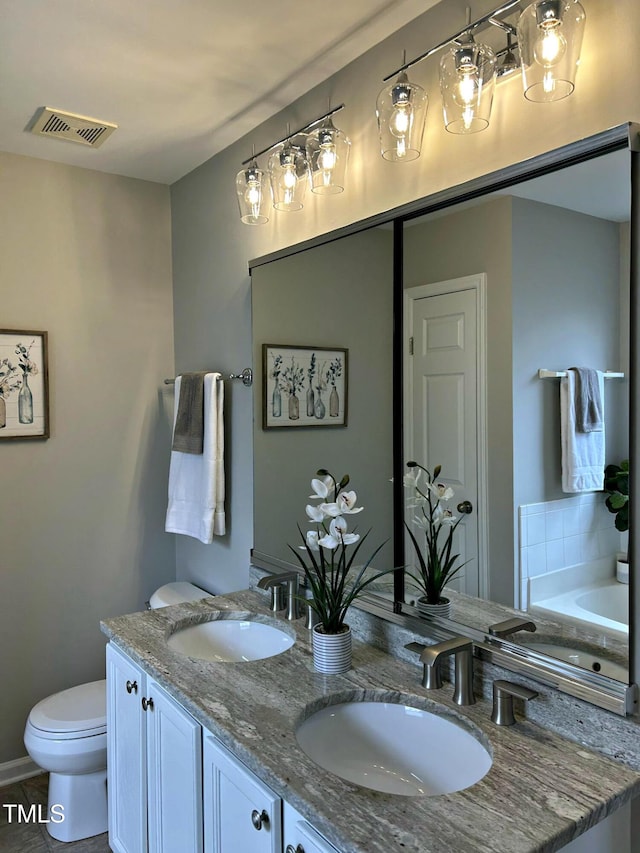 bathroom with vanity, a tub, and toilet