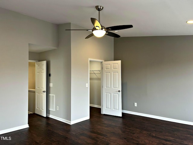 unfurnished bedroom with dark wood-type flooring, ceiling fan, high vaulted ceiling, a spacious closet, and a closet