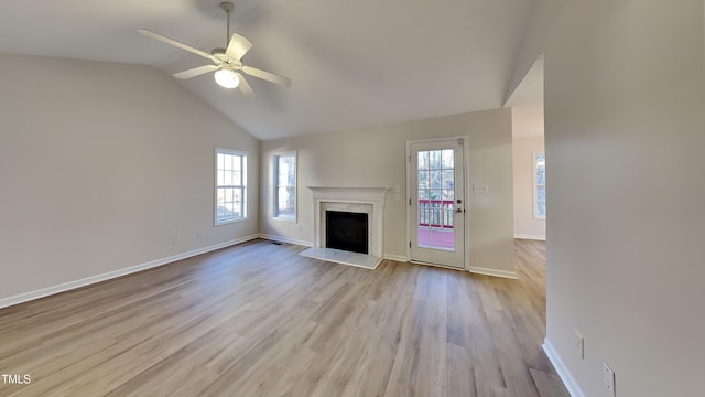 unfurnished living room featuring ceiling fan, a high end fireplace, lofted ceiling, and light wood-type flooring