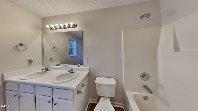 full bathroom featuring toilet, vanity, shower / bath combination, and a textured ceiling