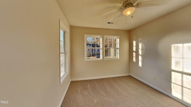 carpeted empty room featuring ceiling fan and a textured ceiling