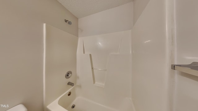 bathroom featuring shower / bathtub combination and a textured ceiling