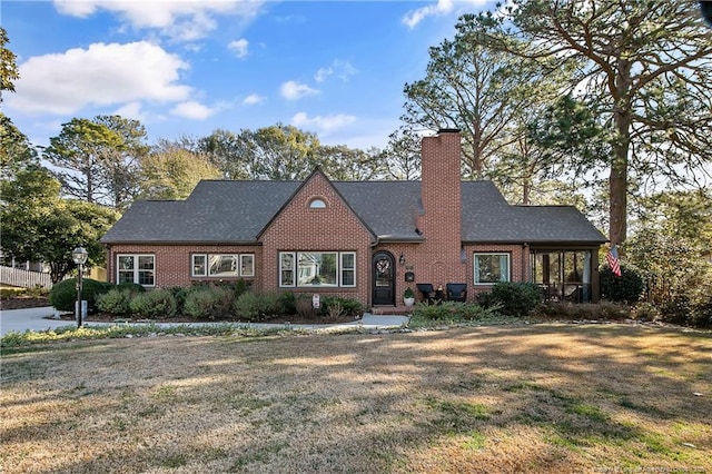 english style home featuring a front yard