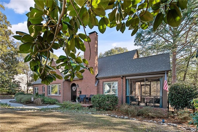 view of front facade featuring a front yard and a sunroom