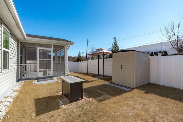 view of yard with a gazebo, a sunroom, a storage unit, and an outdoor fire pit