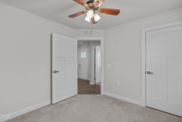 unfurnished bedroom with light colored carpet and ceiling fan