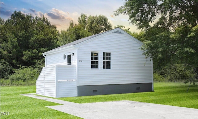 property exterior at dusk with a yard