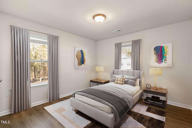 bedroom with dark hardwood / wood-style floors