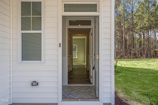 doorway to property featuring a lawn