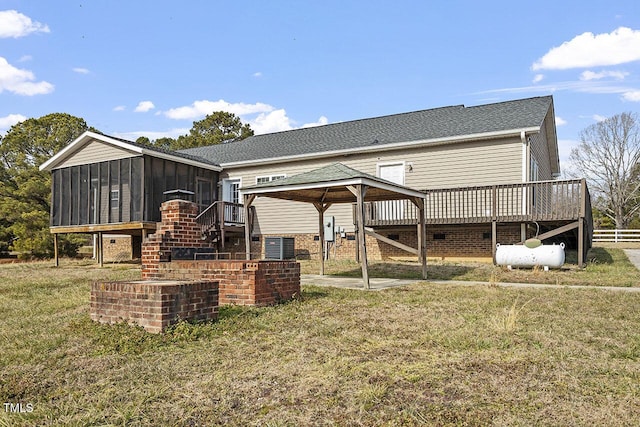 rear view of house with a sunroom, a gazebo, a patio, a lawn, and central air condition unit