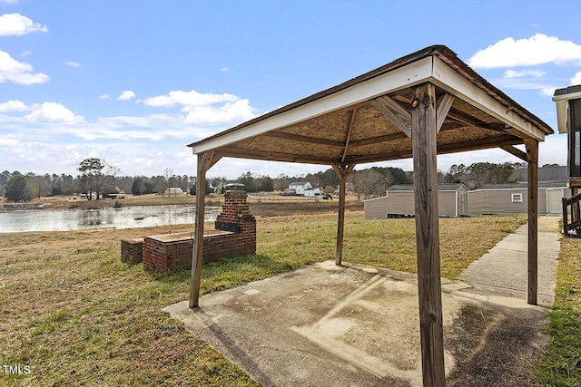 view of patio featuring a gazebo, a shed, and a water view