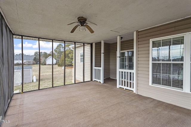 unfurnished sunroom featuring ceiling fan and plenty of natural light