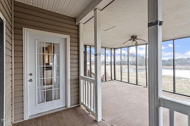 unfurnished sunroom with a water view and ceiling fan