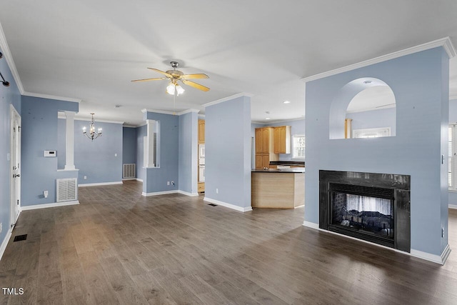 unfurnished living room featuring ceiling fan with notable chandelier, dark hardwood / wood-style flooring, and ornamental molding