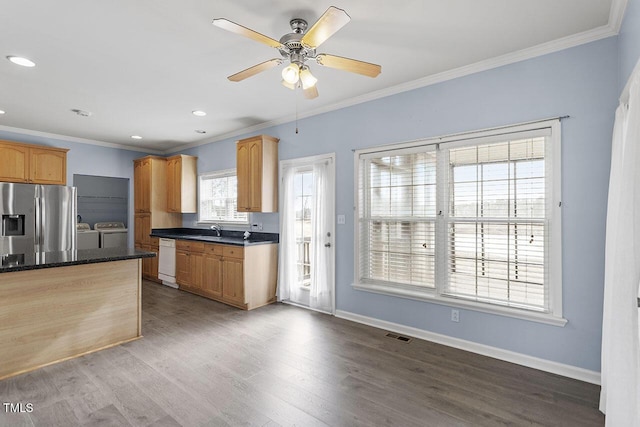 kitchen featuring washer and dryer, sink, stainless steel fridge with ice dispenser, and crown molding