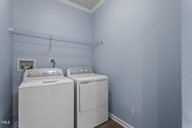 washroom featuring dark hardwood / wood-style floors, crown molding, and washing machine and clothes dryer